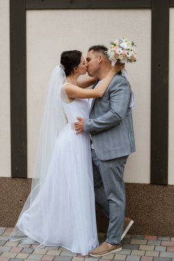young couple the groom in a blue suit and the bride in a white dress on a walk