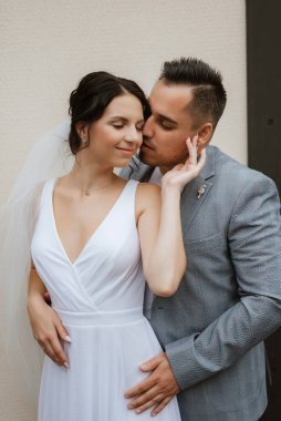 young couple the groom in a blue suit and the bride in a white dress on a walk