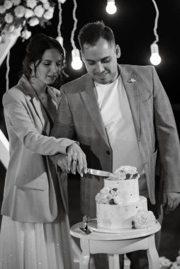 newlyweds happily cut, laugh and taste the wedding cake