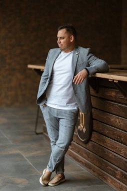 Açık gri takım elbiseli damadın portresi.