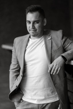 Açık gri takım elbiseli damadın portresi.