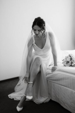 preparations for the bride with the dressing of the wedding dress in the studio