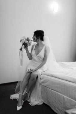 preparations for the bride with the dressing of the wedding dress in the studio