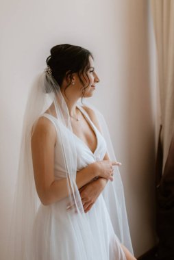preparations for the bride with the dressing of the wedding dress in the studio