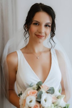 preparations for the bride with the dressing of the wedding dress in the studio
