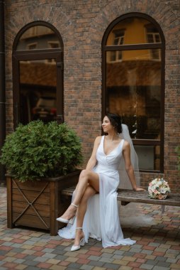 preparations for the bride with the dressing of the wedding dress in the studio