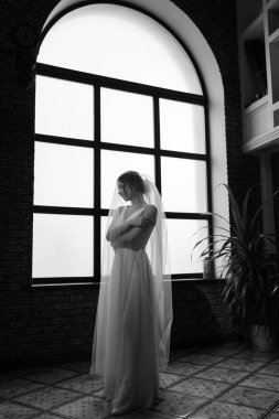 preparations for the bride with the dressing of the wedding dress in the studio