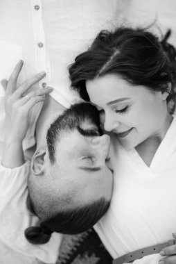 Hamile kız ve erkek arkadaş deniz kenarında beyaz elbiseli piknik yapıyorlar.