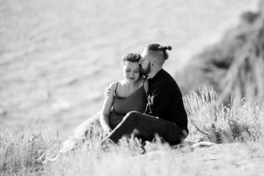 Deniz kenarındaki yüksek tepelerde hamile kız ve erkek arkadaş