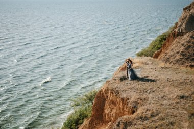 Deniz kenarındaki yüksek tepelerde hamile kız ve erkek arkadaş