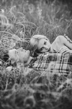 couple in love blonde girl and guy in the grass at sunset