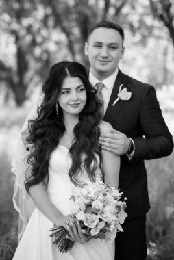 the groom and the bride are walking in the forest on a bright day
