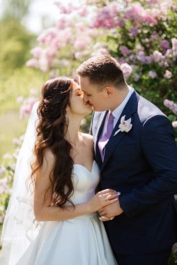 the groom and the bride are walking in the forest on a bright day