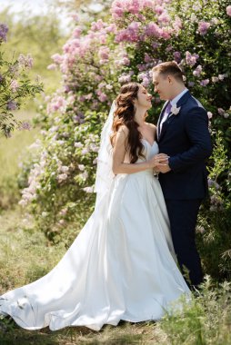 the groom and the bride are walking in the forest on a bright day