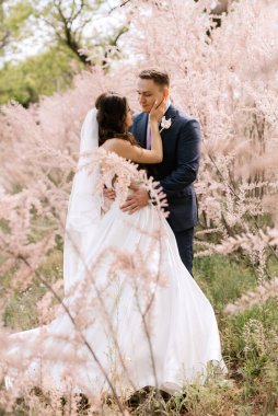 the groom and the bride are walking in the forest on a bright day