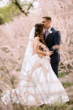 the groom and the bride are walking in the forest on a bright day
