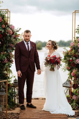 wedding ceremony of the newlyweds on the pier near the restaurant