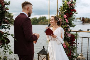 wedding ceremony of the newlyweds on the pier near the restaurant