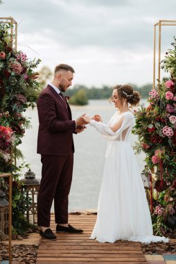 wedding ceremony of the newlyweds on the pier near the restaurant
