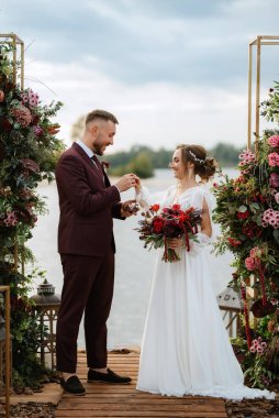 wedding ceremony of the newlyweds on the pier near the restaurant