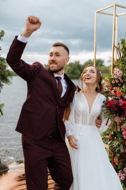 wedding ceremony of the newlyweds on the pier near the restaurant
