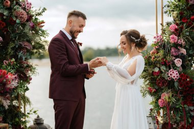 wedding ceremony of the newlyweds on the pier near the restaurant