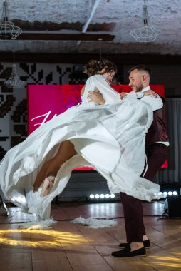 Gelin ve damadın ilk düğün dansı gün batımında restoranın içinde.