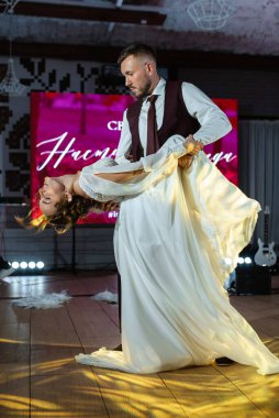 Gelin ve damadın ilk düğün dansı gün batımında restoranın içinde.