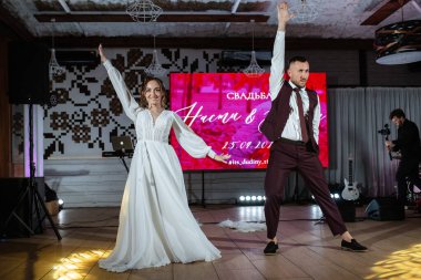 Gelin ve damadın ilk düğün dansı gün batımında restoranın içinde.