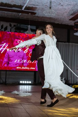 Gelin ve damadın ilk düğün dansı gün batımında restoranın içinde.