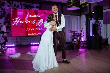 Gelin ve damadın ilk düğün dansı gün batımında restoranın içinde.