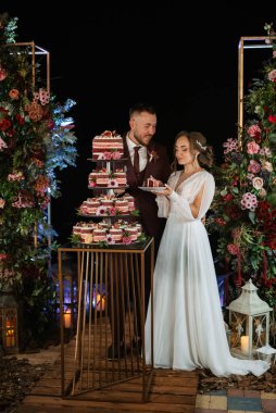 newlyweds happily cut, laugh and taste the wedding cake