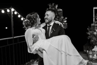 newlyweds in the evening on the wedding arch on the pier after the ceremony