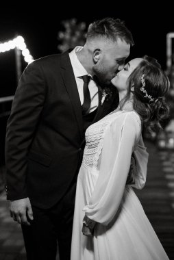 newlyweds in the evening on the wedding arch on the pier after the ceremony