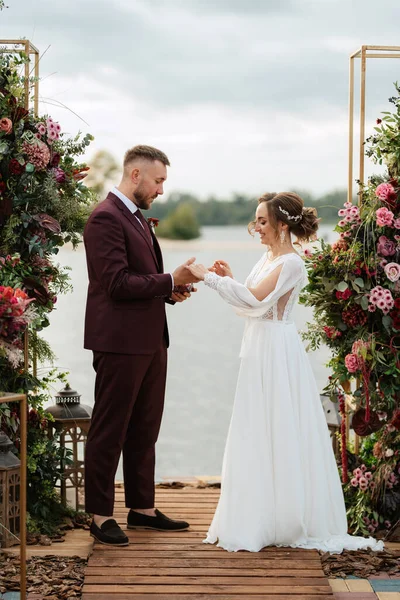 wedding ceremony of the newlyweds on the pier near the restaurant