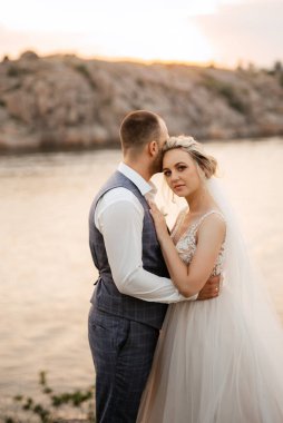 bride blonde girl and groom near the river at sunset light