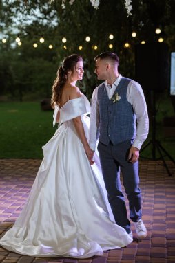 Gelin ve damadın ilk düğün dansı gün batımında restoranın içinde.