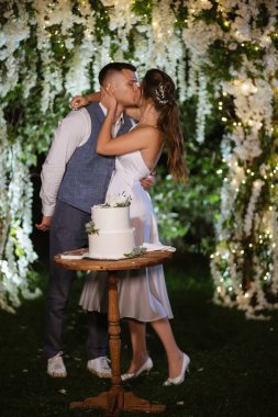 newlyweds happily cut, laugh and taste the wedding cake