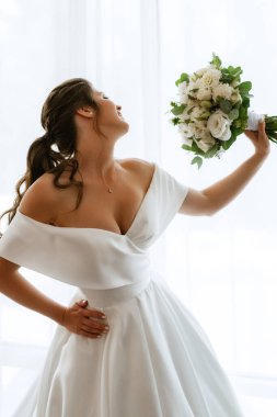 preparations for the bride with the dressing of the wedding dress in the studio