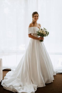 preparations for the bride with the dressing of the wedding dress in the studio