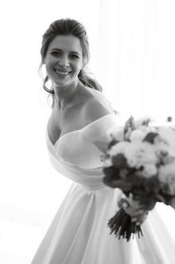 preparations for the bride with the dressing of the wedding dress in the studio