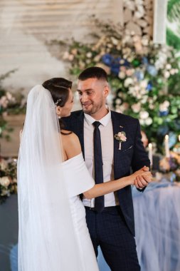 Gelin ve damadın ilk düğün dansı gün batımında restoranın içinde.