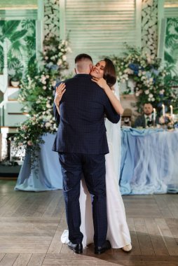 Gelin ve damadın ilk düğün dansı gün batımında restoranın içinde.