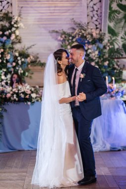 Gelin ve damadın ilk düğün dansı gün batımında restoranın içinde.