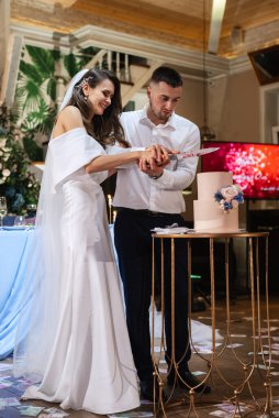 newlyweds happily cut, laugh and taste the wedding cake