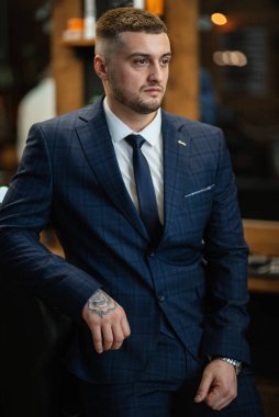 portrait of a bearded groom guy in a dark blue suit