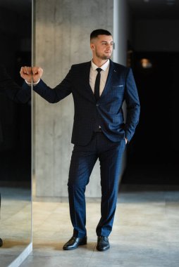 portrait of a bearded groom guy in a dark blue suit