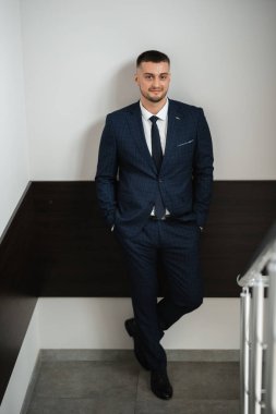portrait of a bearded groom guy in a dark blue suit