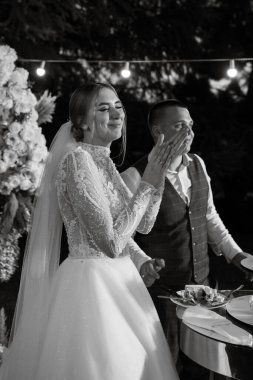newlyweds happily cut, laugh and taste the wedding cake