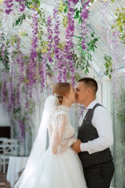 young couple the groom in a plaid suit and the bride in a chic white dress in nature